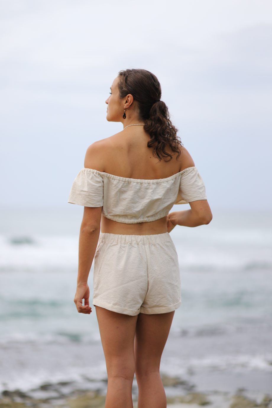 Higher Himalayan's 'Q Top' offers a blend of bohemian charm and eco-friendly fashion. This off-shoulder top, crafted from organic Himalayan hemp, features a ruffled neckline that exudes a playful yet elegant vibe. Its cropped cut and breezy fit encapsulate a free-spirited aesthetic while showcasing sustainable luxury.