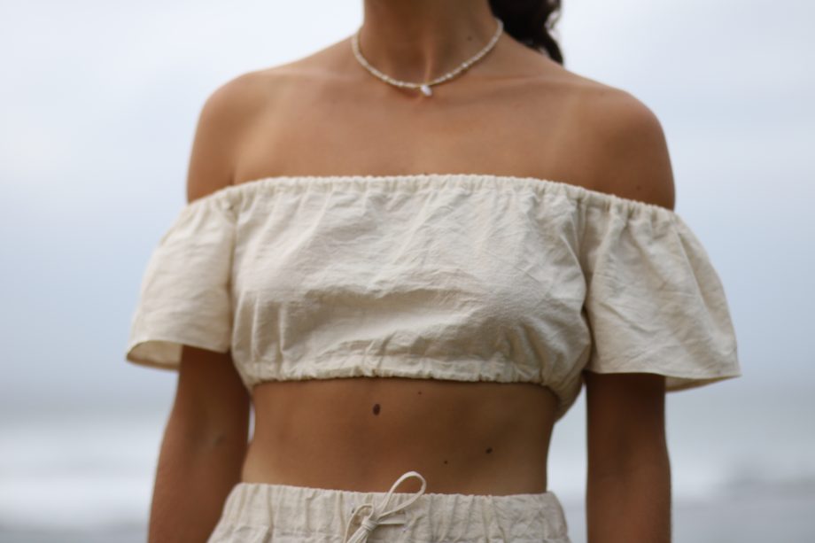 Higher Himalayan's 'Q Top' offers a blend of bohemian charm and eco-friendly fashion. This off-shoulder top, crafted from organic Himalayan hemp, features a ruffled neckline that exudes a playful yet elegant vibe. Its cropped cut and breezy fit encapsulate a free-spirited aesthetic while showcasing sustainable luxury.