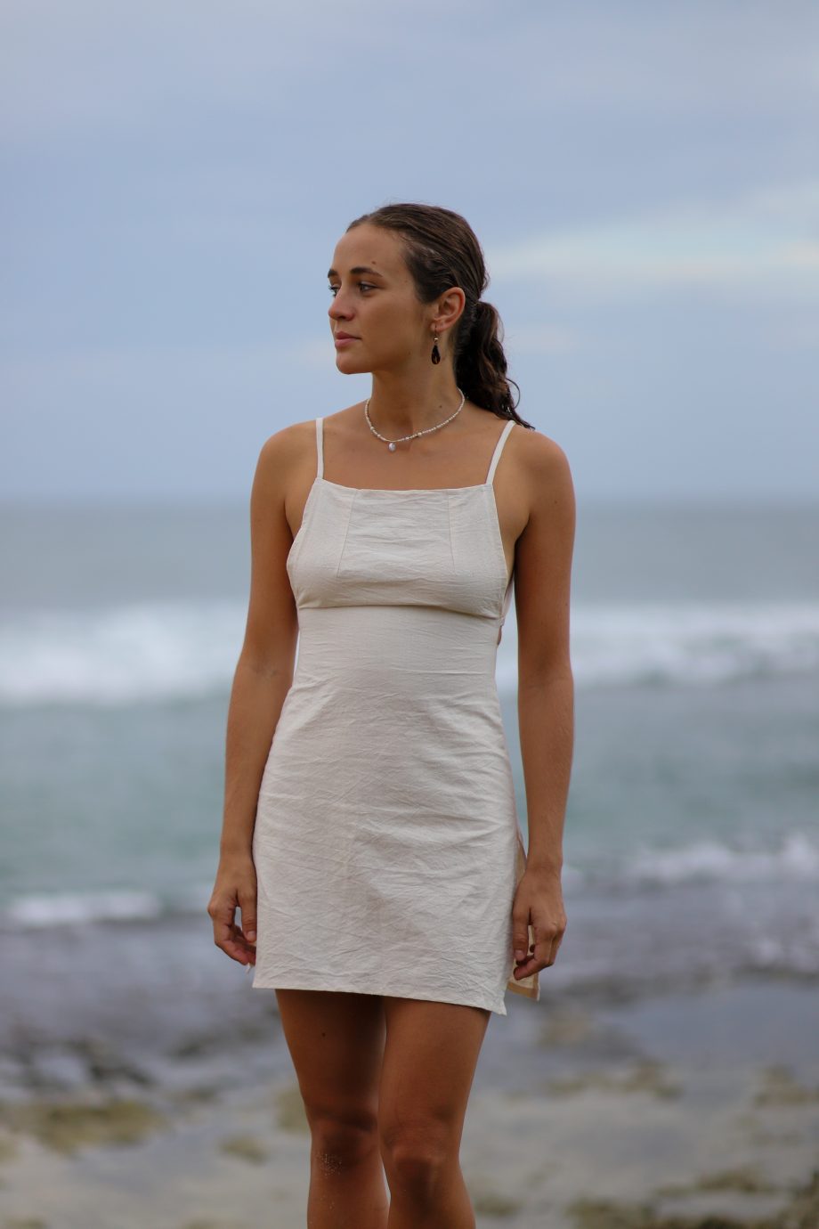 Experience the essence of the Himalayas with Higher Himalayan's eco-conscious hemp mini dress. Handcrafted from ethically sourced, organic Himalayan hemp, this off-white dress epitomizes minimalist elegance. Its square neckline and delicate straps create a look that's both sexy and decent, perfect for the eco-aware young adult. The back's adjustable tie closure hints at the hand-made care and attention to detail by designers Chathu and Hui. Ideal for beachgoers or those indulging in yoga and meditation, this dress blends the durability of hemp with the comfort of natural fibers, inviting wearers to elevate their style while embracing a sustainable, slow fashion lifestyle