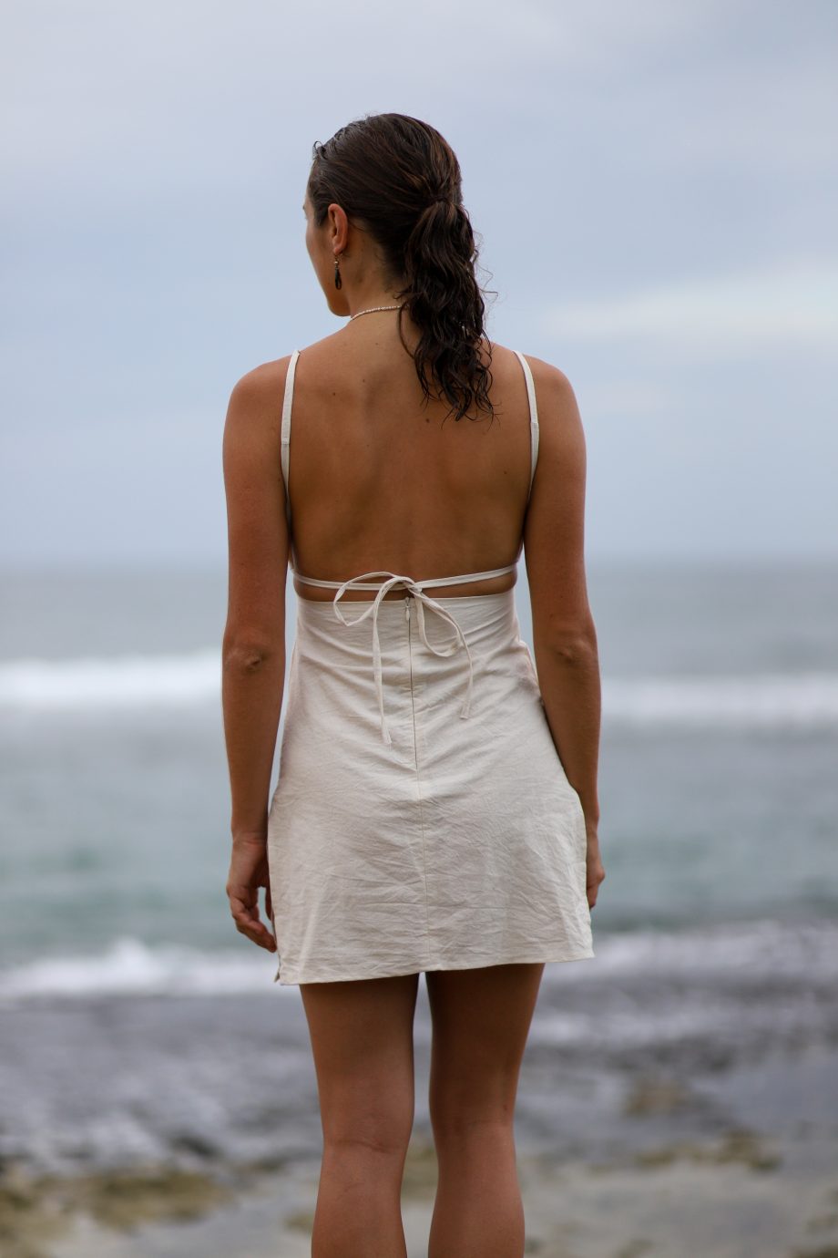 Experience the essence of the Himalayas with Higher Himalayan's eco-conscious hemp mini dress. Handcrafted from ethically sourced, organic Himalayan hemp, this off-white dress epitomizes minimalist elegance. Its square neckline and delicate straps create a look that's both sexy and decent, perfect for the eco-aware young adult. The back's adjustable tie closure hints at the hand-made care and attention to detail by designers Chathu and Hui. Ideal for beachgoers or those indulging in yoga and meditation, this dress blends the durability of hemp with the comfort of natural fibers, inviting wearers to elevate their style while embracing a sustainable, slow fashion lifestyle