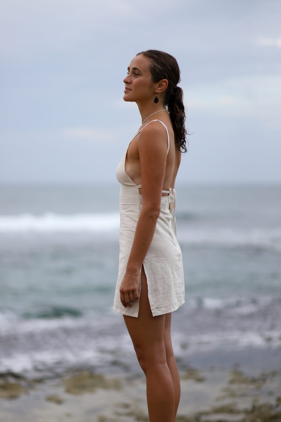 Experience the essence of the Himalayas with Higher Himalayan's eco-conscious hemp mini dress. Handcrafted from ethically sourced, organic Himalayan hemp, this off-white dress epitomizes minimalist elegance. Its square neckline and delicate straps create a look that's both sexy and decent, perfect for the eco-aware young adult. The back's adjustable tie closure hints at the hand-made care and attention to detail by designers Chathu and Hui. Ideal for beachgoers or those indulging in yoga and meditation, this dress blends the durability of hemp with the comfort of natural fibers, inviting wearers to elevate their style while embracing a sustainable, slow fashion lifestyle